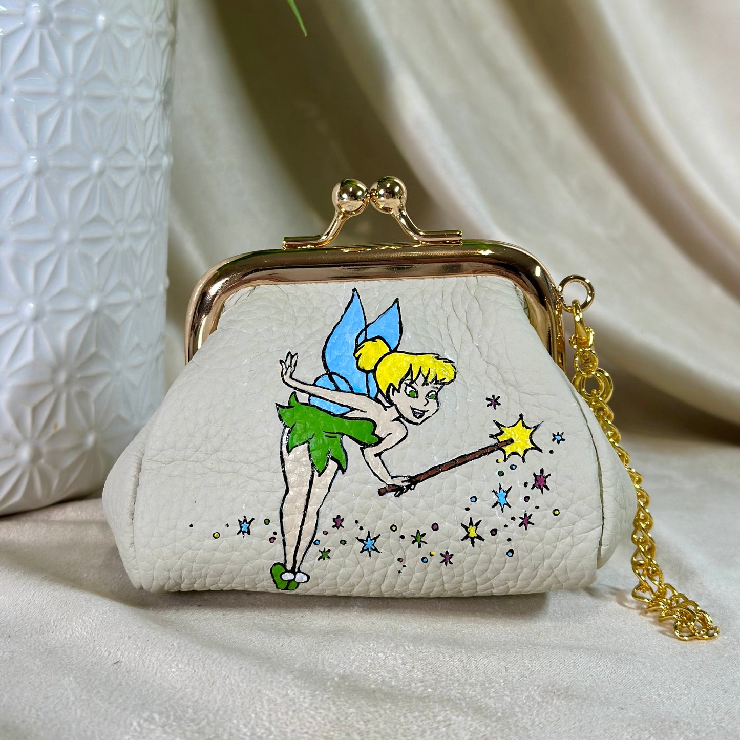 Small white purse with Tinker Bell design on a light background