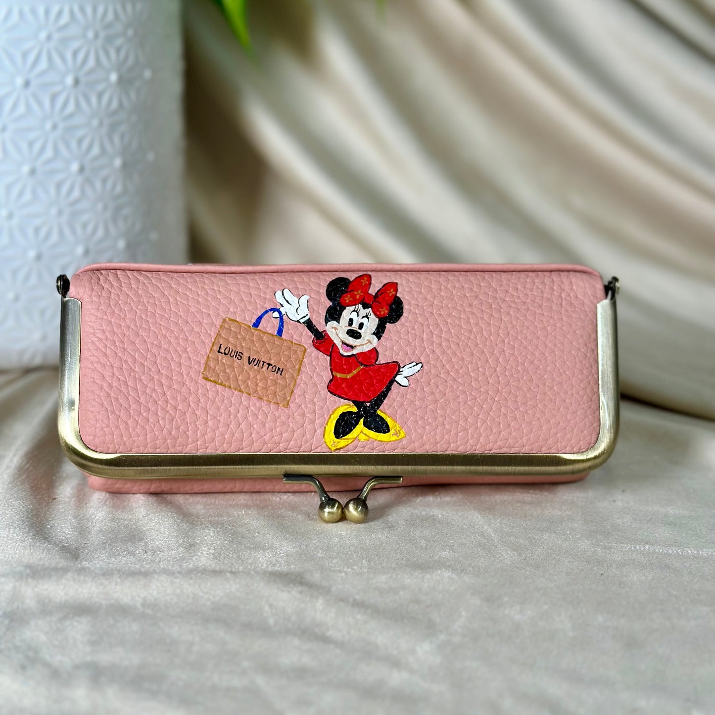 Pink pouch with cartoon character design on a light surface