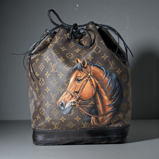 Designer handbag with horse painting on a gray background