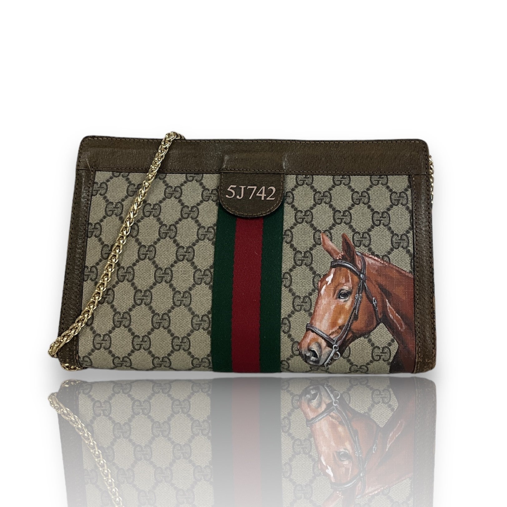 Designer handbag with horse illustration and Gucci logo on a white background