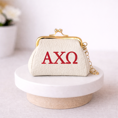 White handbag with red 'AXO' letters on a white surface