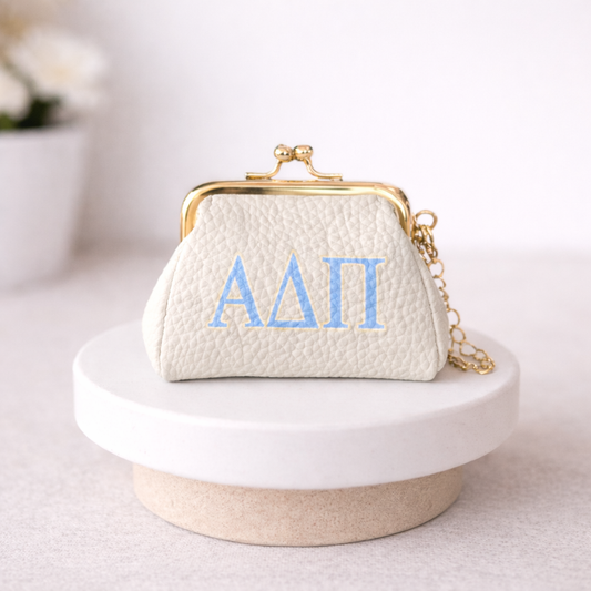 White handbag with blue letters on a white surface