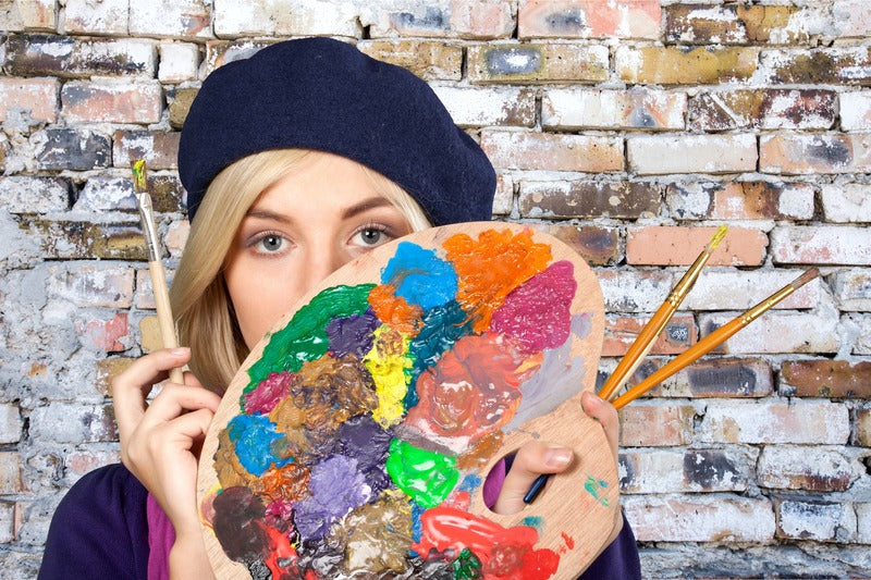 Lady holding paint brushes