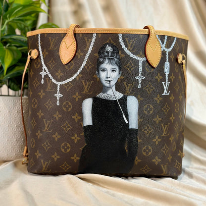 Designer handbag with artistic depiction of a woman on a beige background