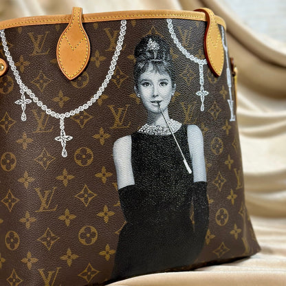 Designer handbag with a portrait of a Audrey Hepburn on a beige fabric background