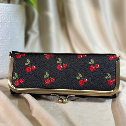 Black wallet with red cherry pattern on a light surface