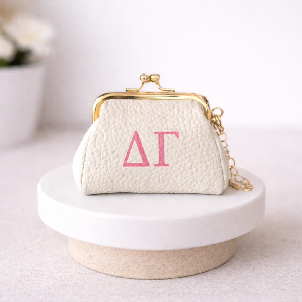 Small white handbag with gold clasp and pink letters on a white surface