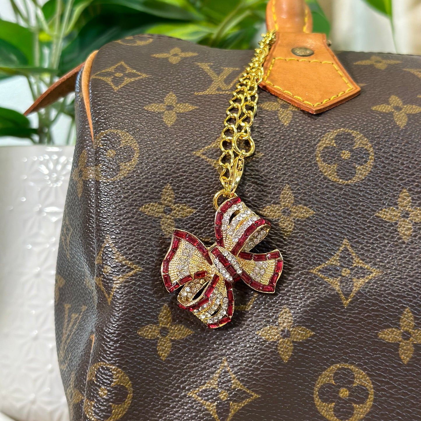 Designer handbag with a decorative bow charm on a blurred background