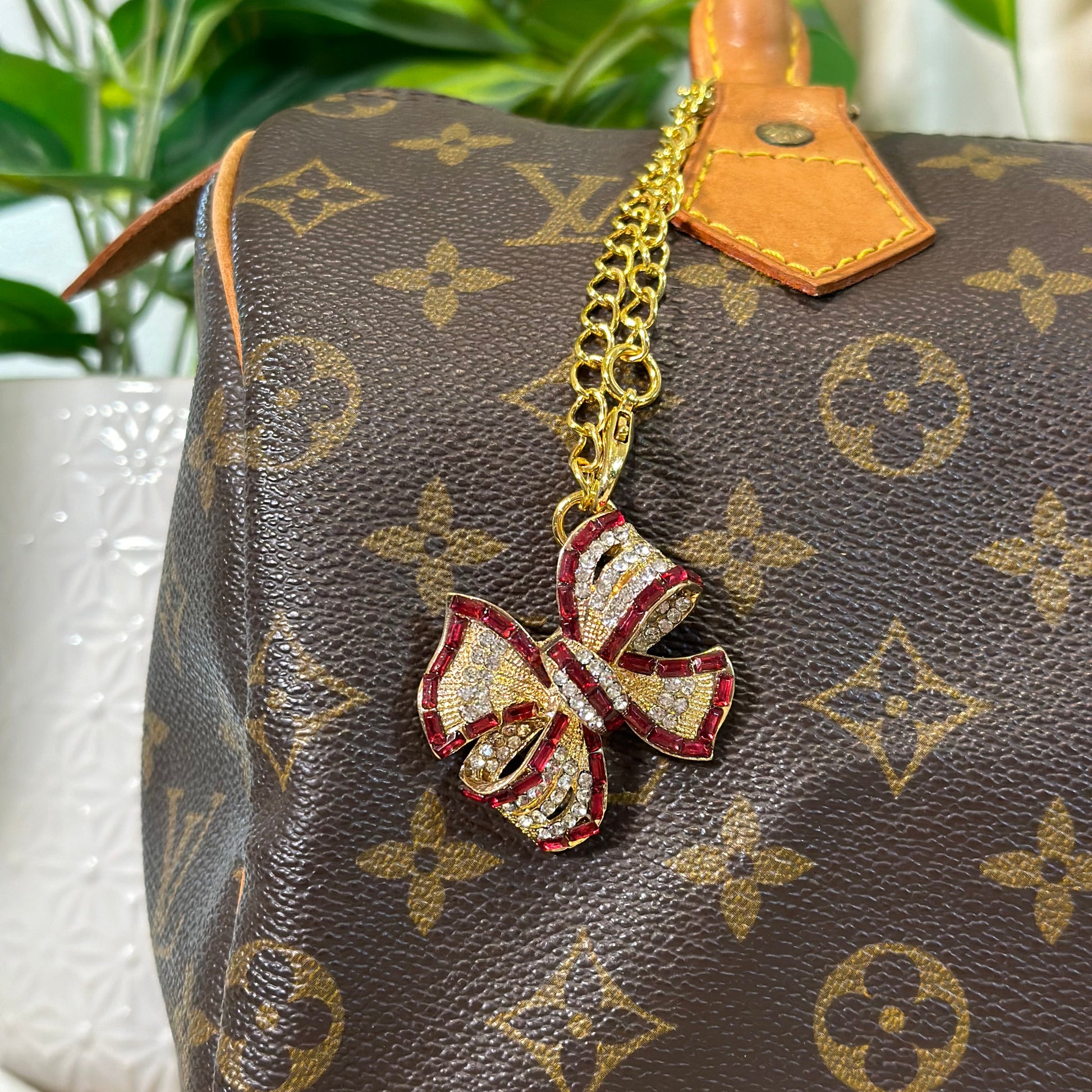 Designer handbag with a decorative bow charm on a blurred background