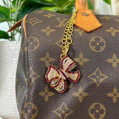 Designer handbag with a decorative bow charm on a blurred background
