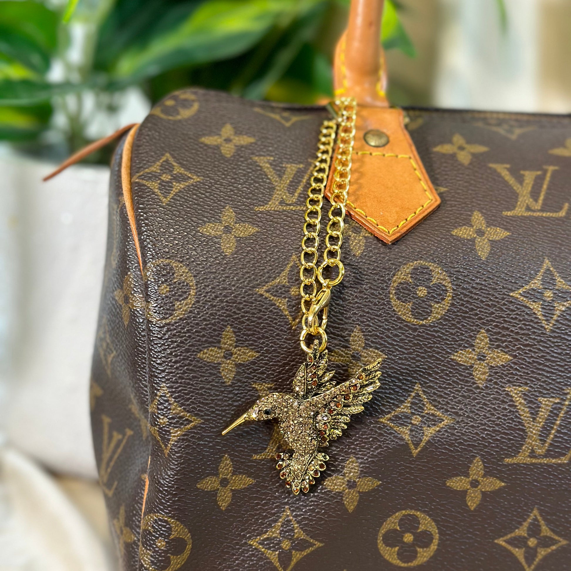 Gold necklace with a pendant on a Louis Vuitton handbag