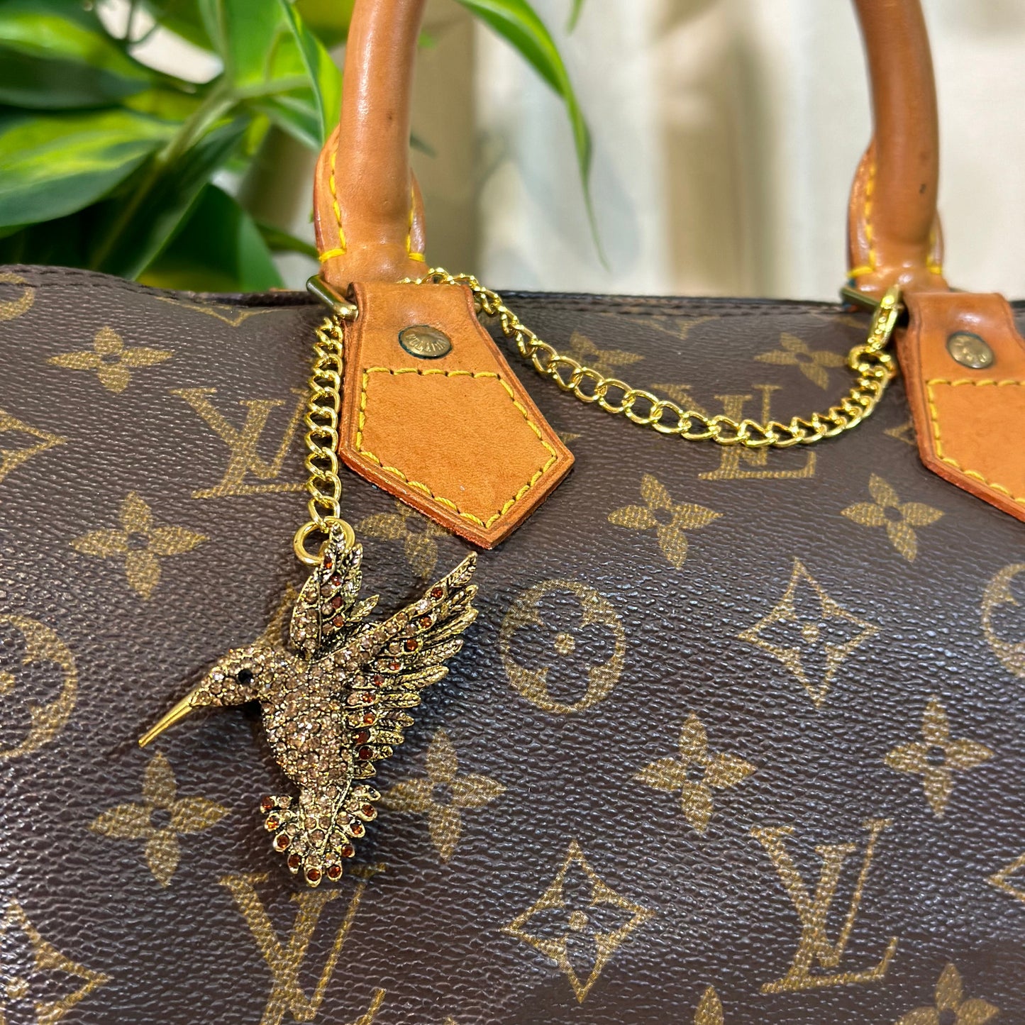 Louis Vuitton handbag with a decorative charm on a blurred background