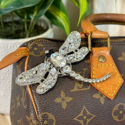 Silver butterfly brooch on a Louis Vuitton handbag