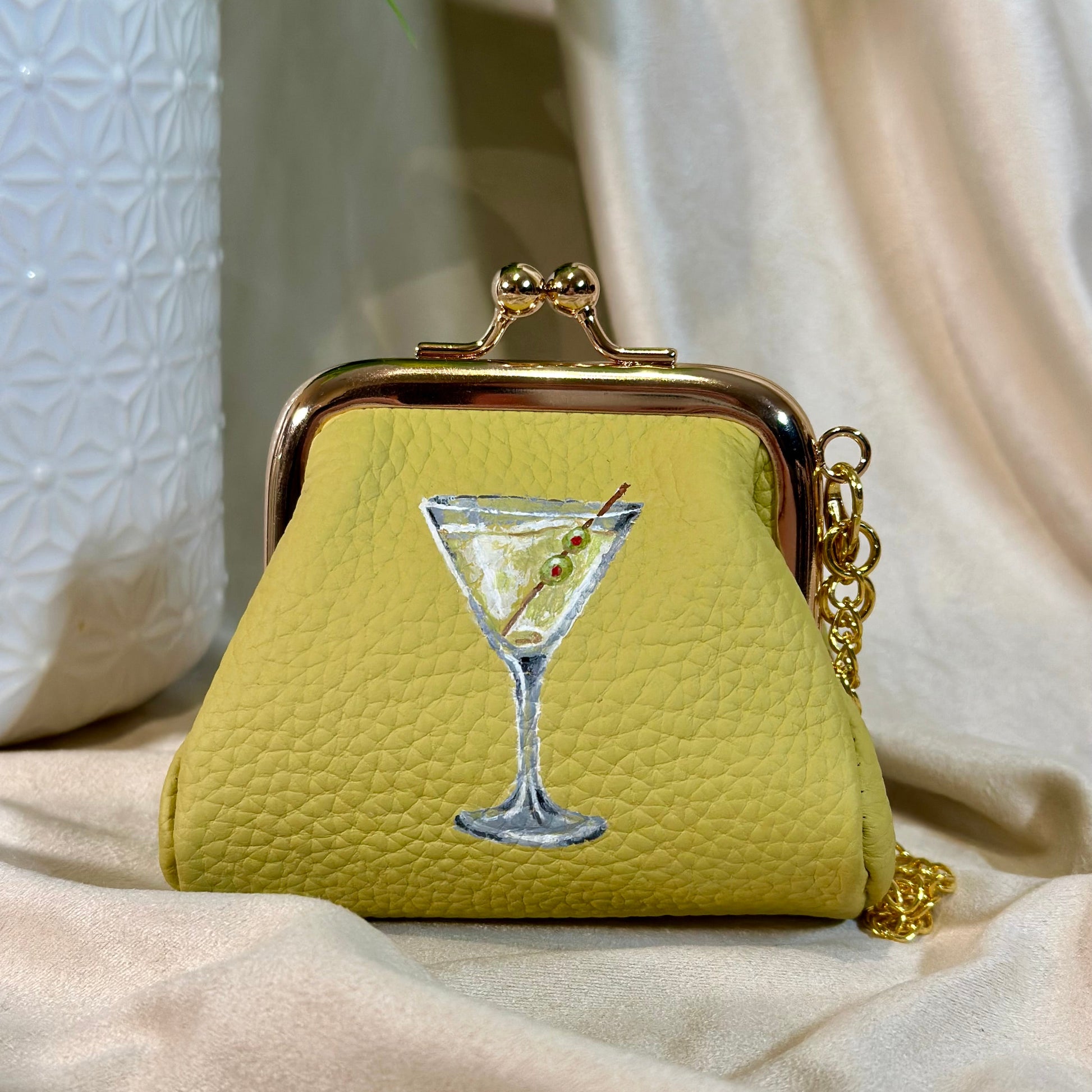 Yellow purse with a martini glass design on a beige surface