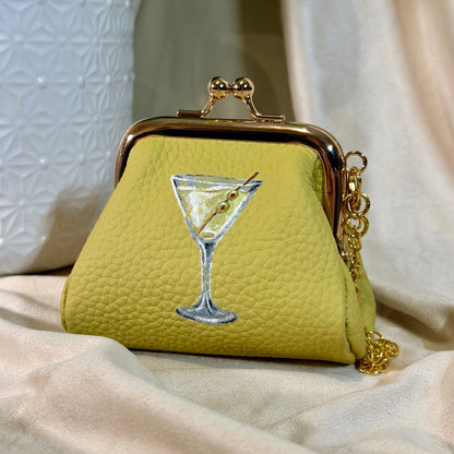 Green purse with martini glass design on a beige surface