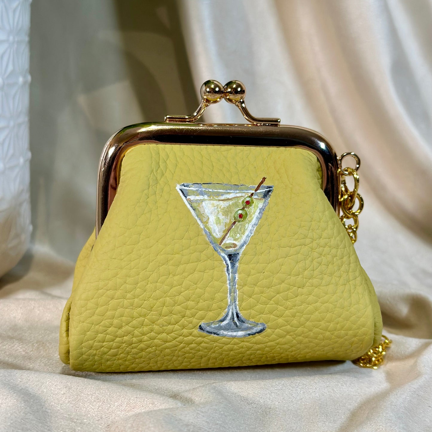 Yellow purse with a martini glass design on a light background