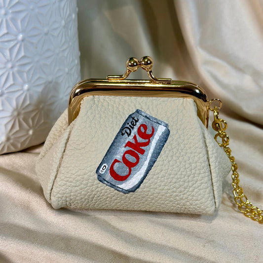 Beige handbag with a 'Diet Coke' label on a beige fabric background