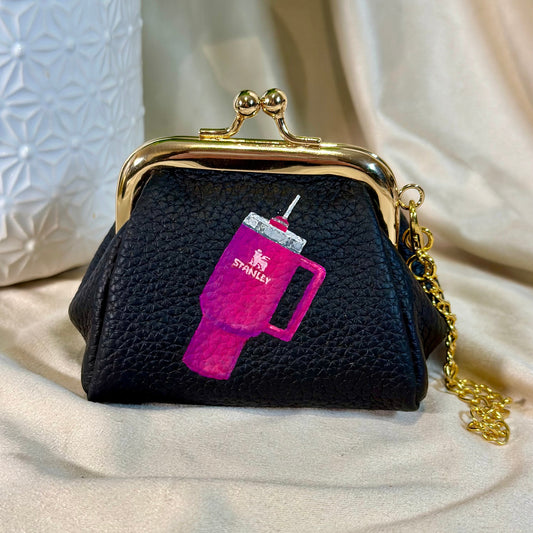 Black textured coin purse with pink and purple design on a beige surface