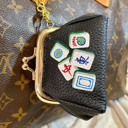 Black leather pouch with Mahjong tile designs on a Louis Vuitton monogram bag.