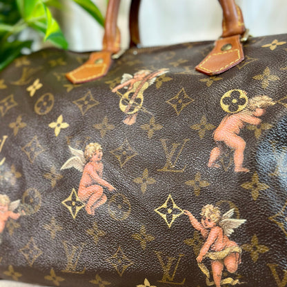 Designer handbag with cherub and monogram pattern on a neutral background
