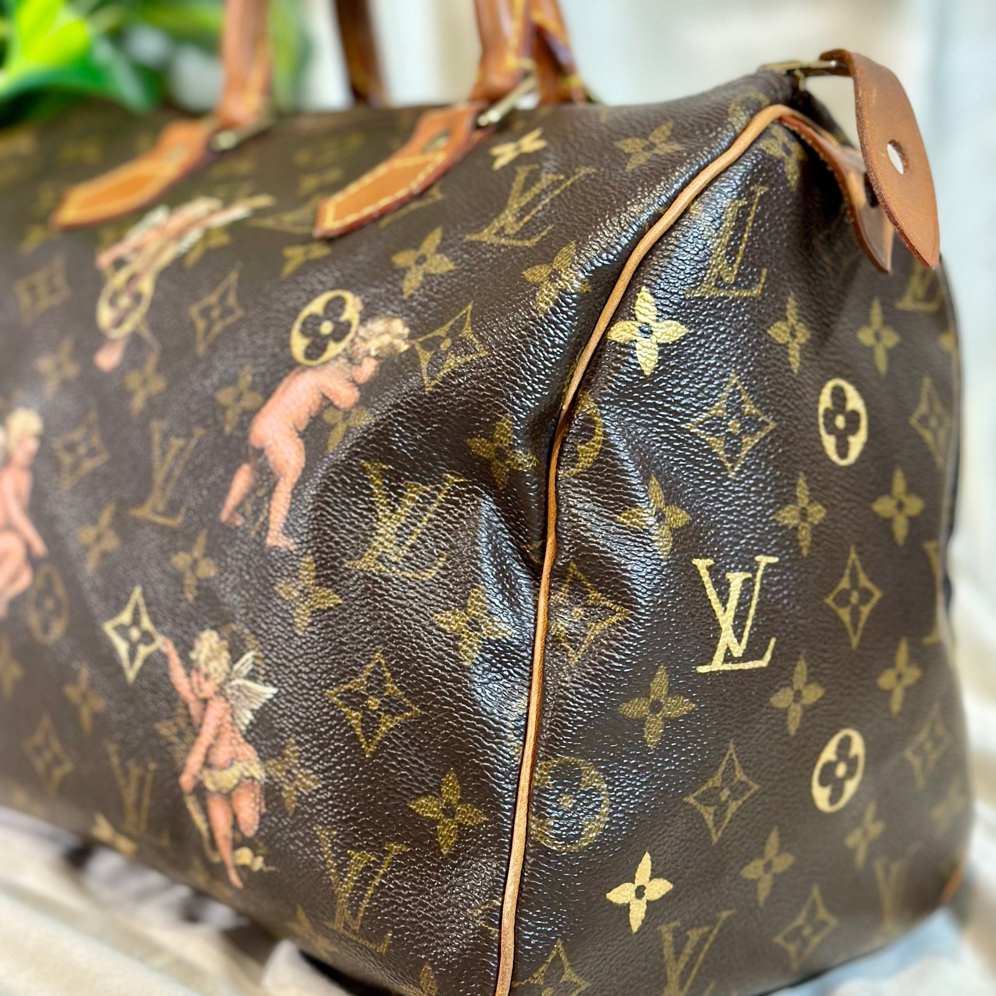 Designer handbag with monogram pattern on a neutral background