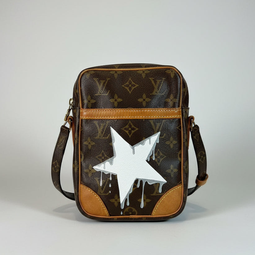 Designer handbag with a white star design on a neutral background
