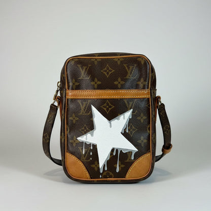 Designer handbag with a white star design on a neutral background