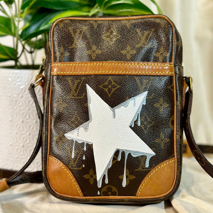 Designer handbag with a white star design on a neutral background
