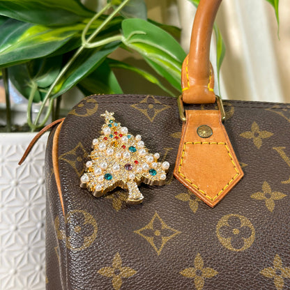Louis Vuitton handbag with a decorative brooch on a blurred background