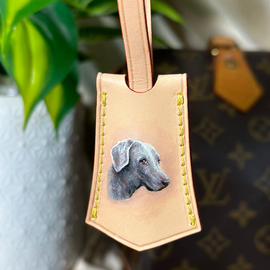 Leather luggage tag with dog illustration on a blurred background