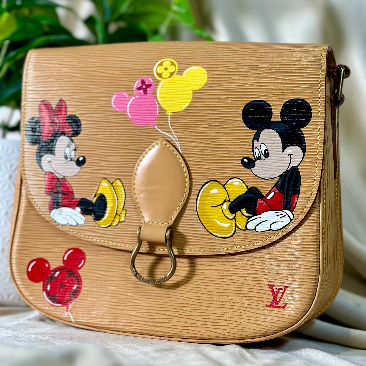 Beige handbag with cartoon characters on a neutral background