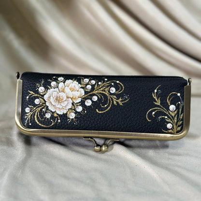 Decorative black case with floral design on a beige fabric background