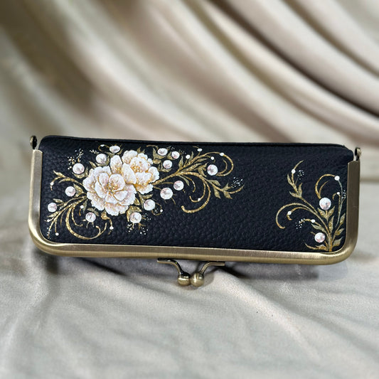 Decorative black case with floral design on a beige fabric background