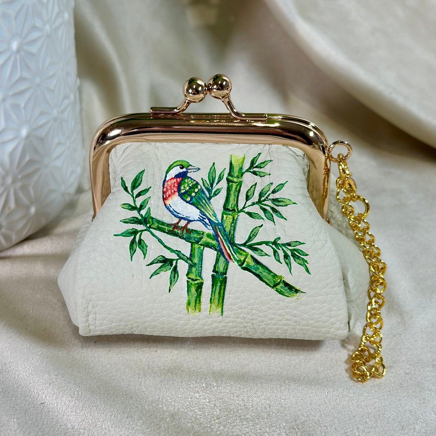 Small pouch with bird and bamboo design on a light background