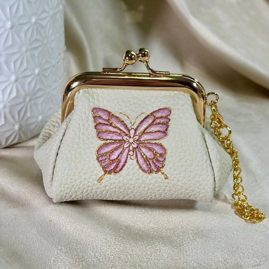 Small white purse with a pink butterfly design on a light background