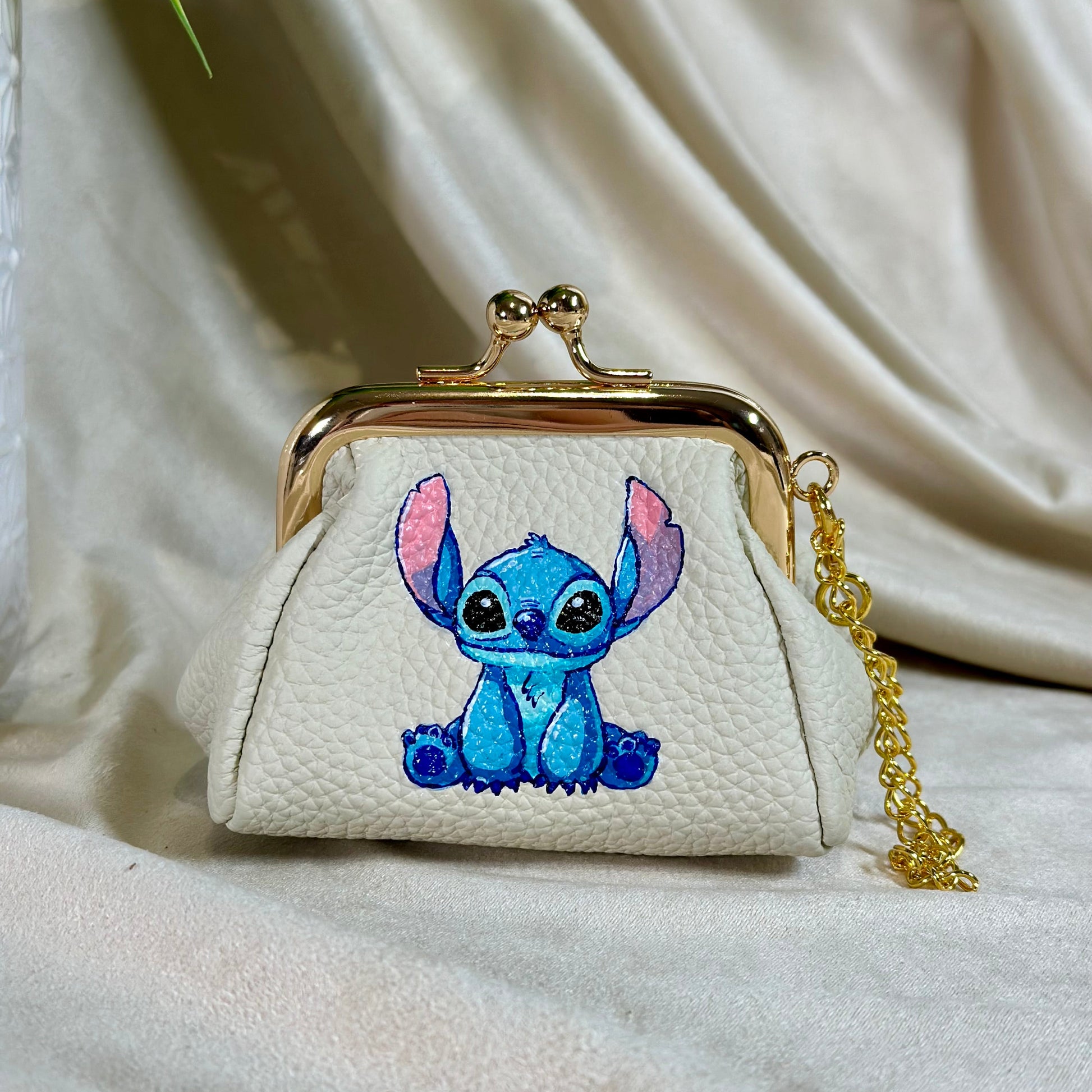 Small white purse with a cartoon character on a beige fabric background