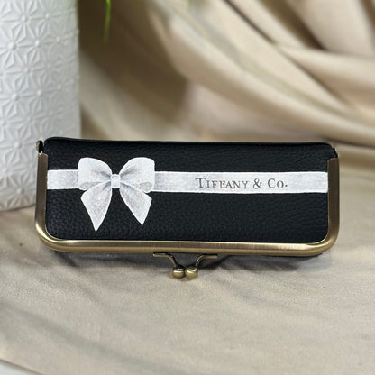 Tiffany & Co. jewelry box with a white bow on a beige surface