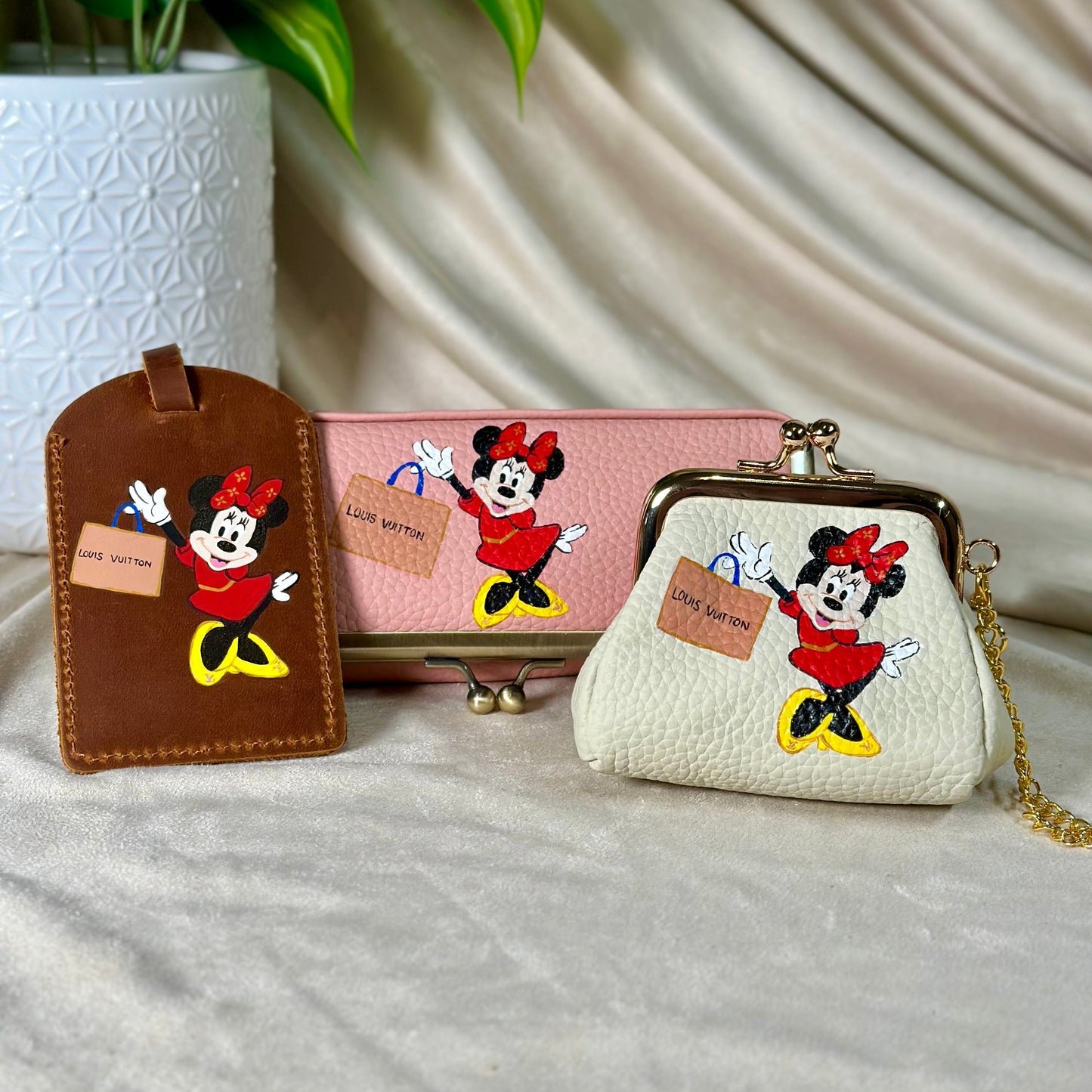 Set of Disney-themed pouches and luggage tag on a neutral background