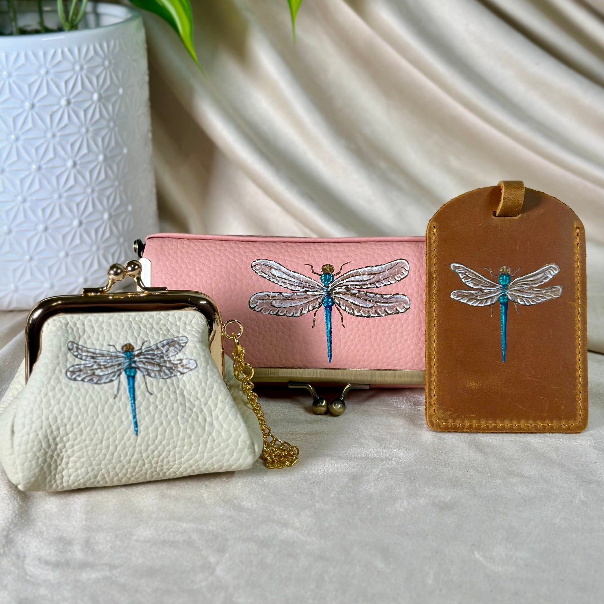 Three small bags with dragonfly designs on a light fabric background