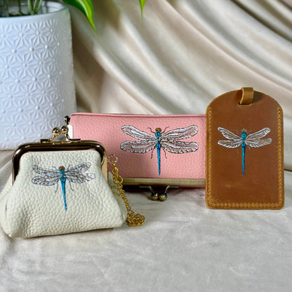 Three small bags with dragonfly designs on a light fabric background