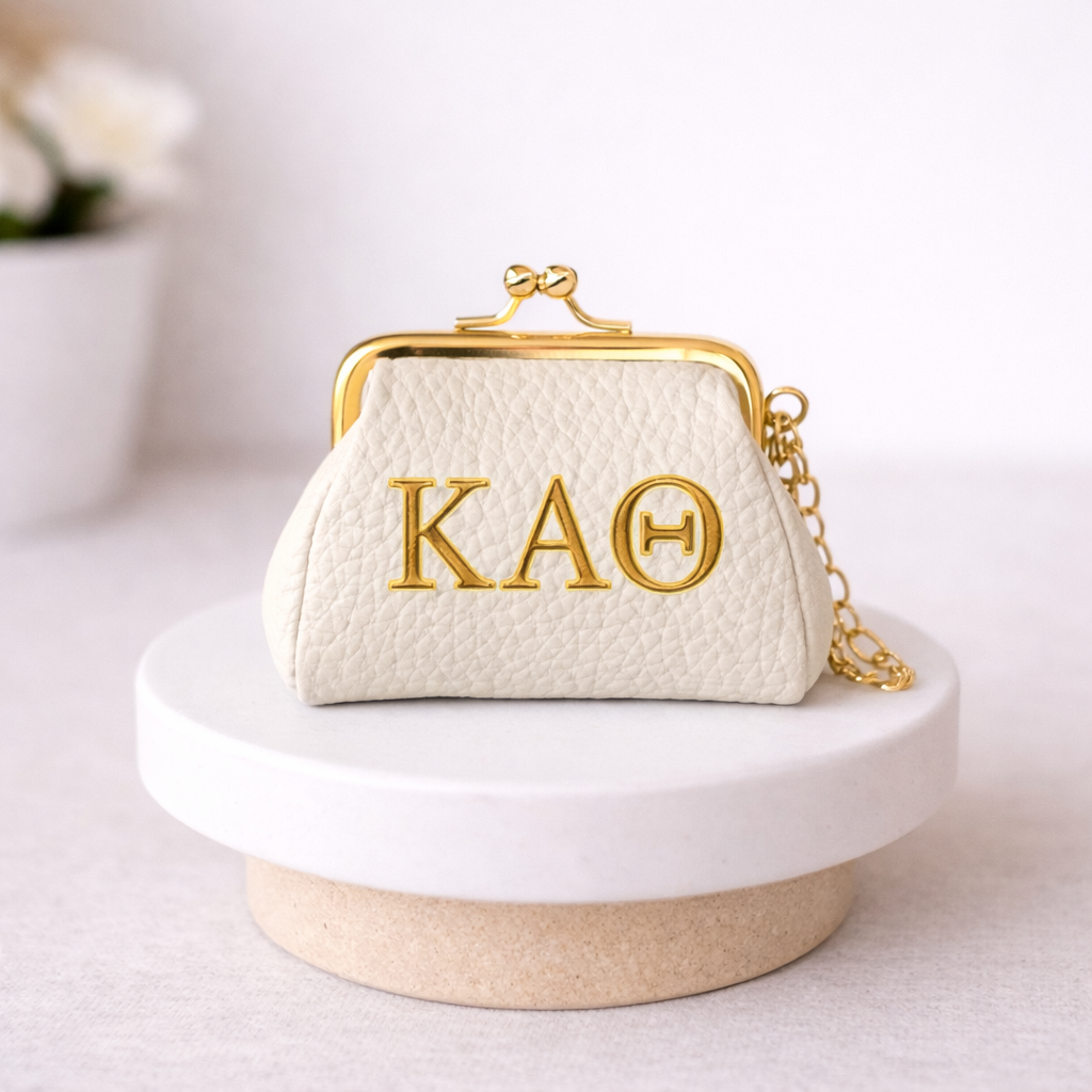 White handbag with gold chain and 'KAOTheta' monogram on a white surface