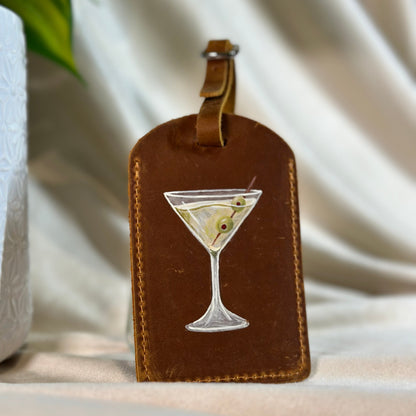 Brown leather luggage tag with a martini glass design on a neutral background