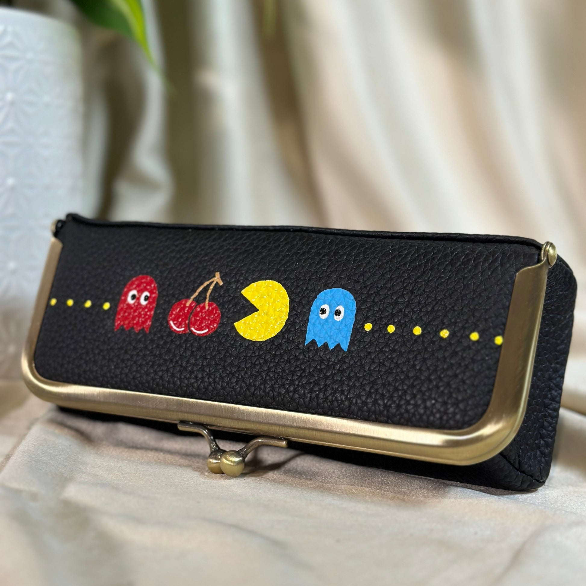 Black pouch with colorful character designs on a light background