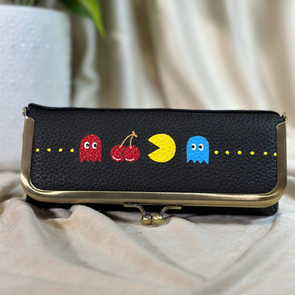 Black pouch with colorful character designs on a beige surface