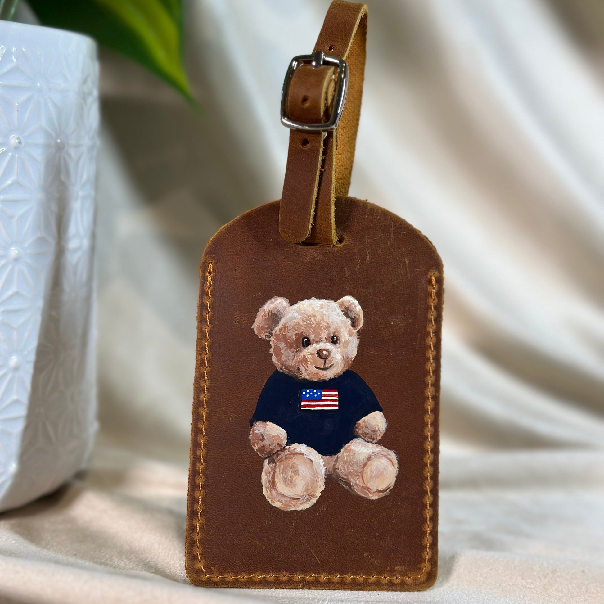 Brown luggage tag painted with a teddy bear