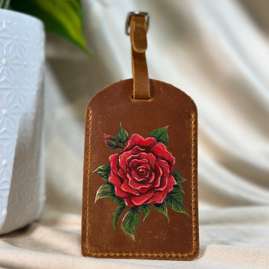 A hand painted rose on a luggage tag