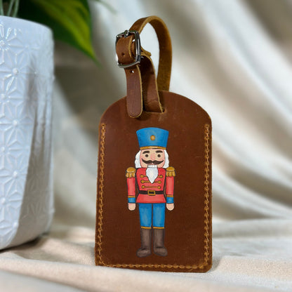 Brown leather luggage tag with nutcracker design on a light background