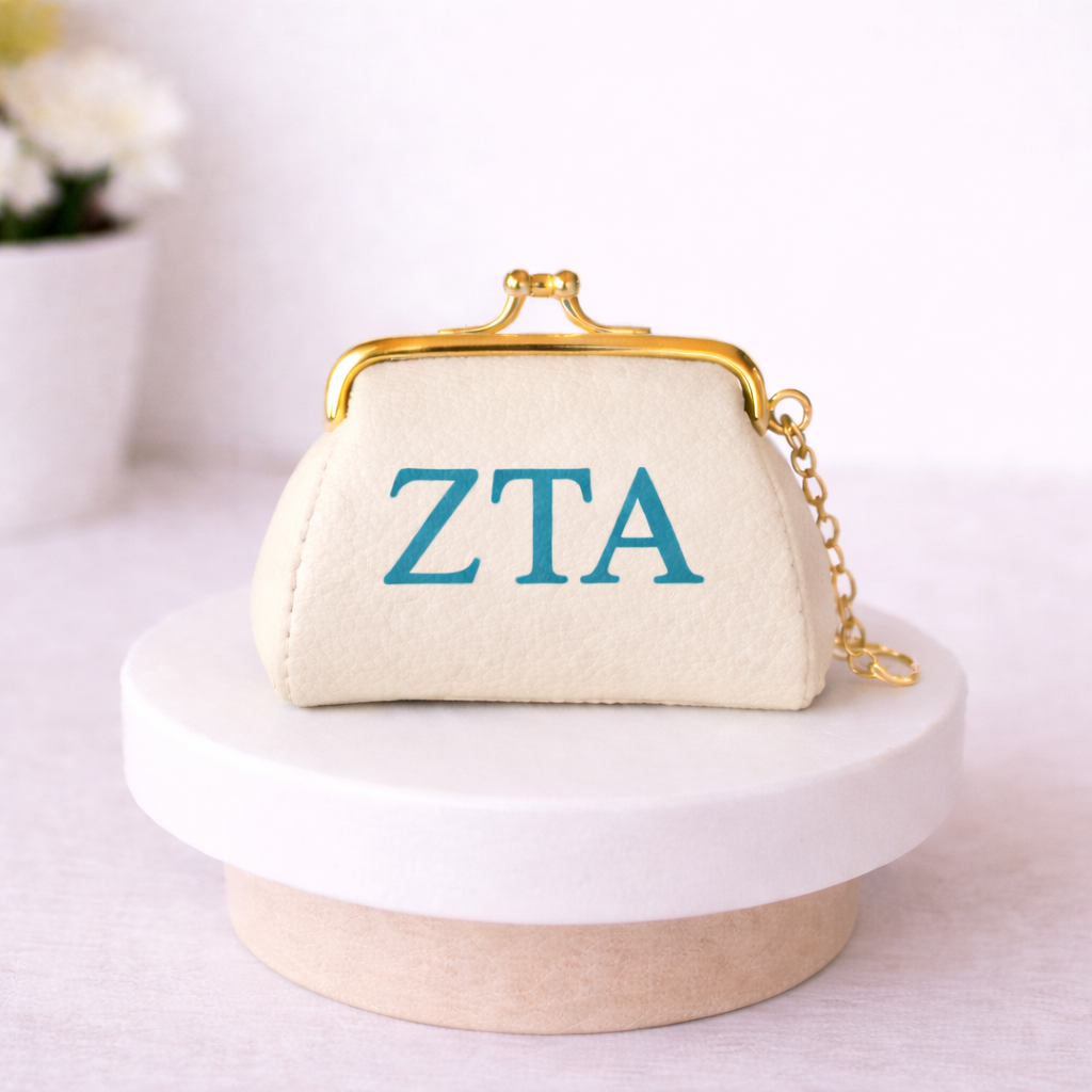 Small cream-colored purse with 'ZTA' in blue letters on a white surface.